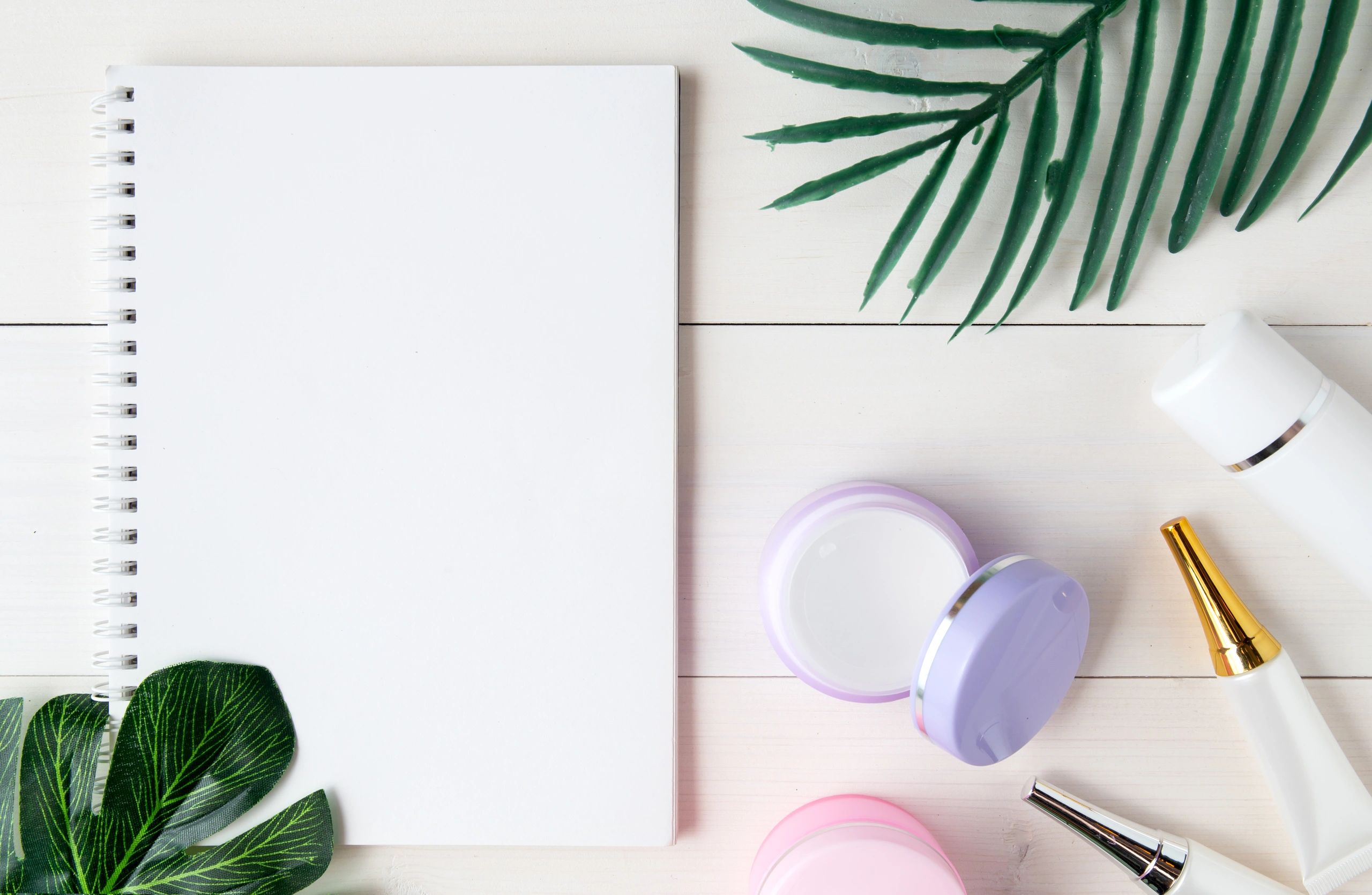 Flat lay of skincare products and notebook